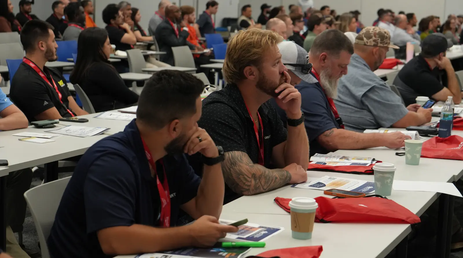Conference attendees reviewing printed materials during a construction technology session on change-order fee erosion